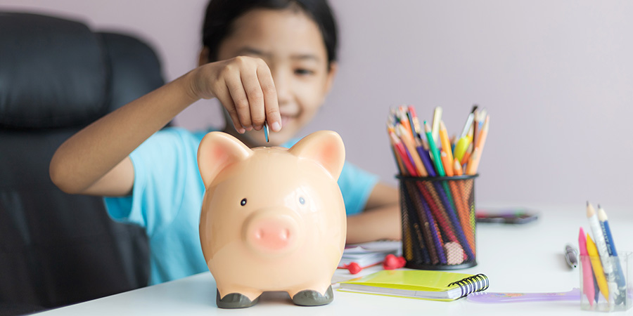 Student putting money in a piggy bank