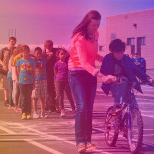 Afterschool teacher teaching bicycle safety to children